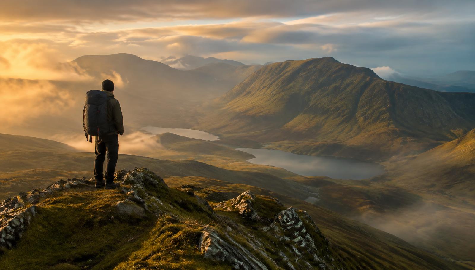 Hiker on a highland ridge at sunrise